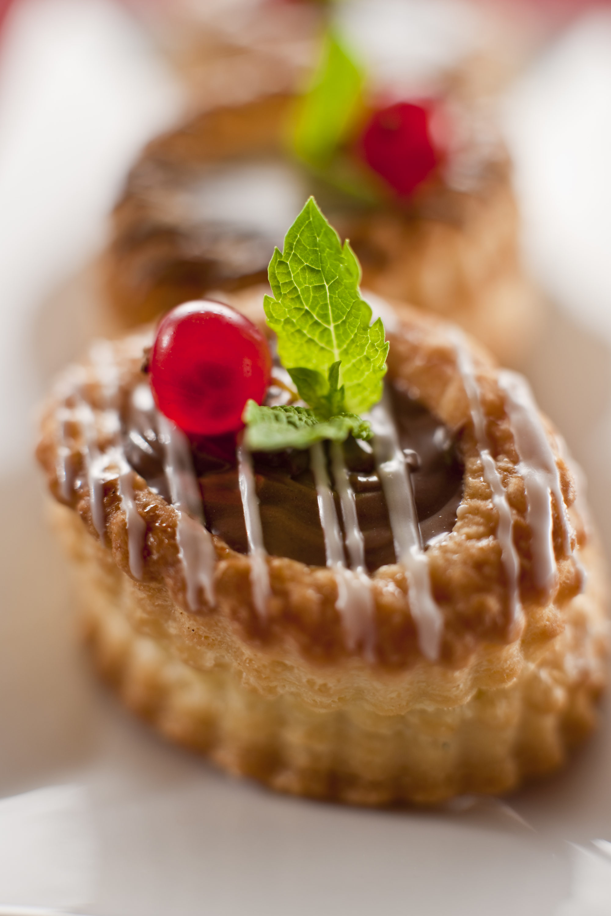 Foto di tortino ripieno di cioccolato e decorato con ribes e foglie di menta