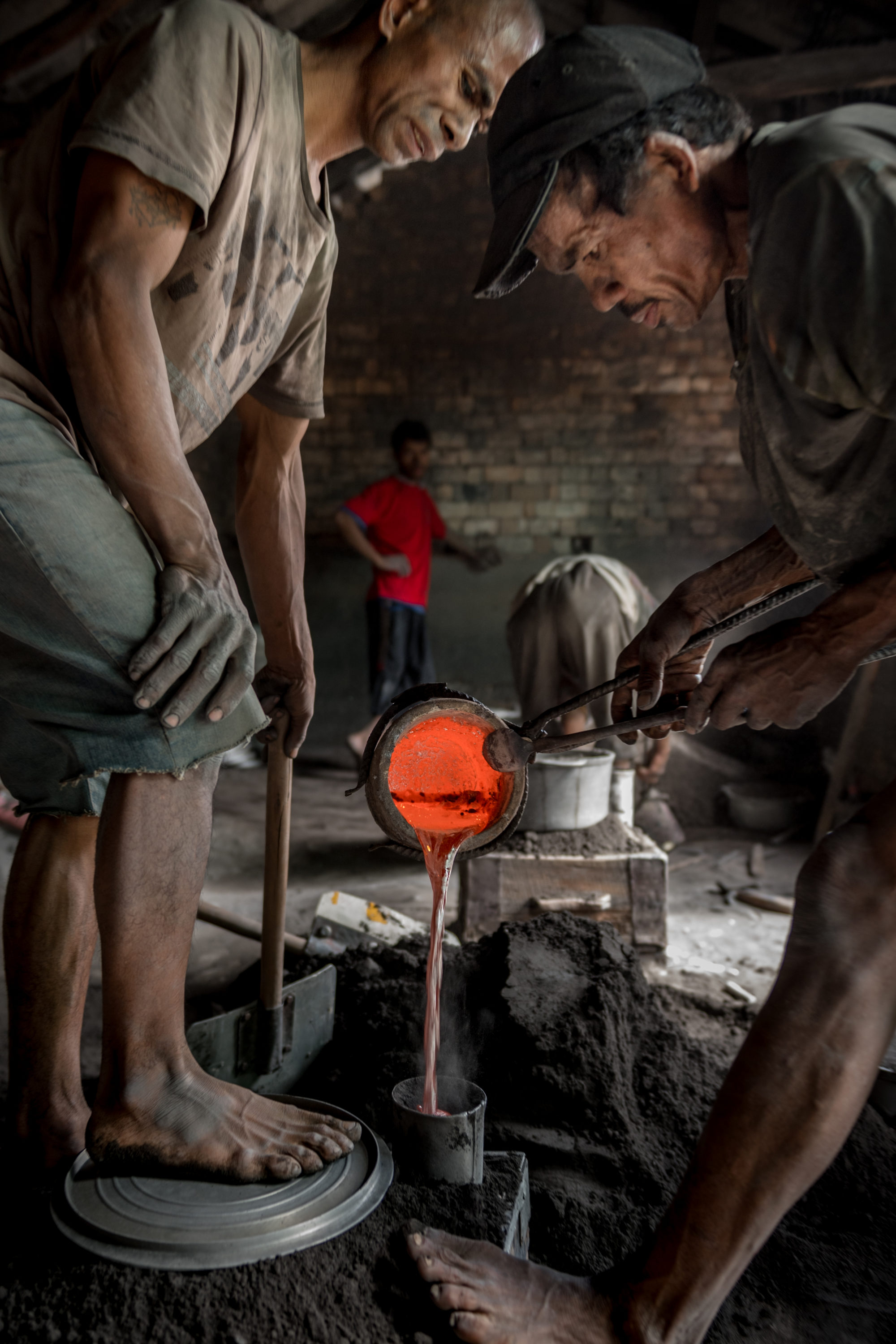 Foto di ragazzi al lavoro in una fonderia di alluminio nell’area di antsohihy