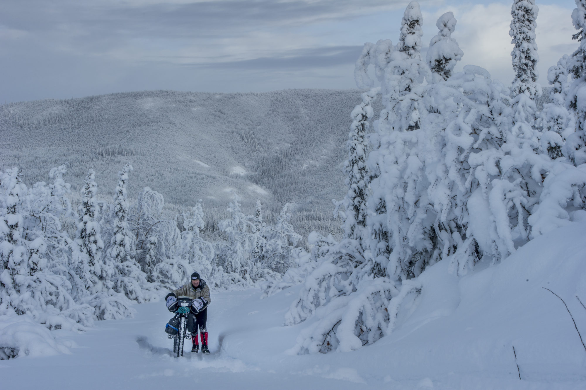 Foto di aldo mazzocchi che spinge a fatica la sua fat bike su un trail innevato