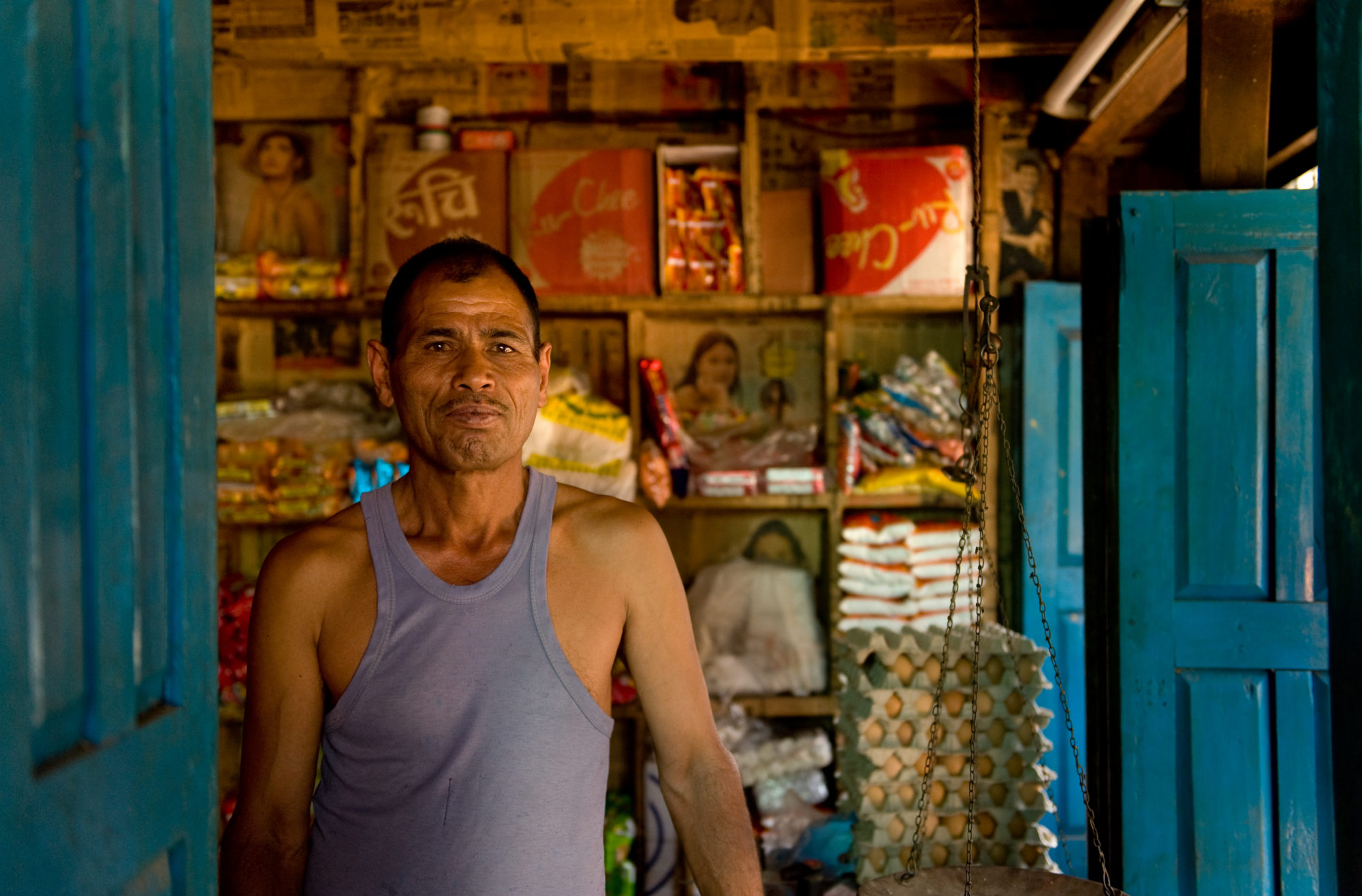 Foto di Uomo all’interno del suo negozio in Nepal