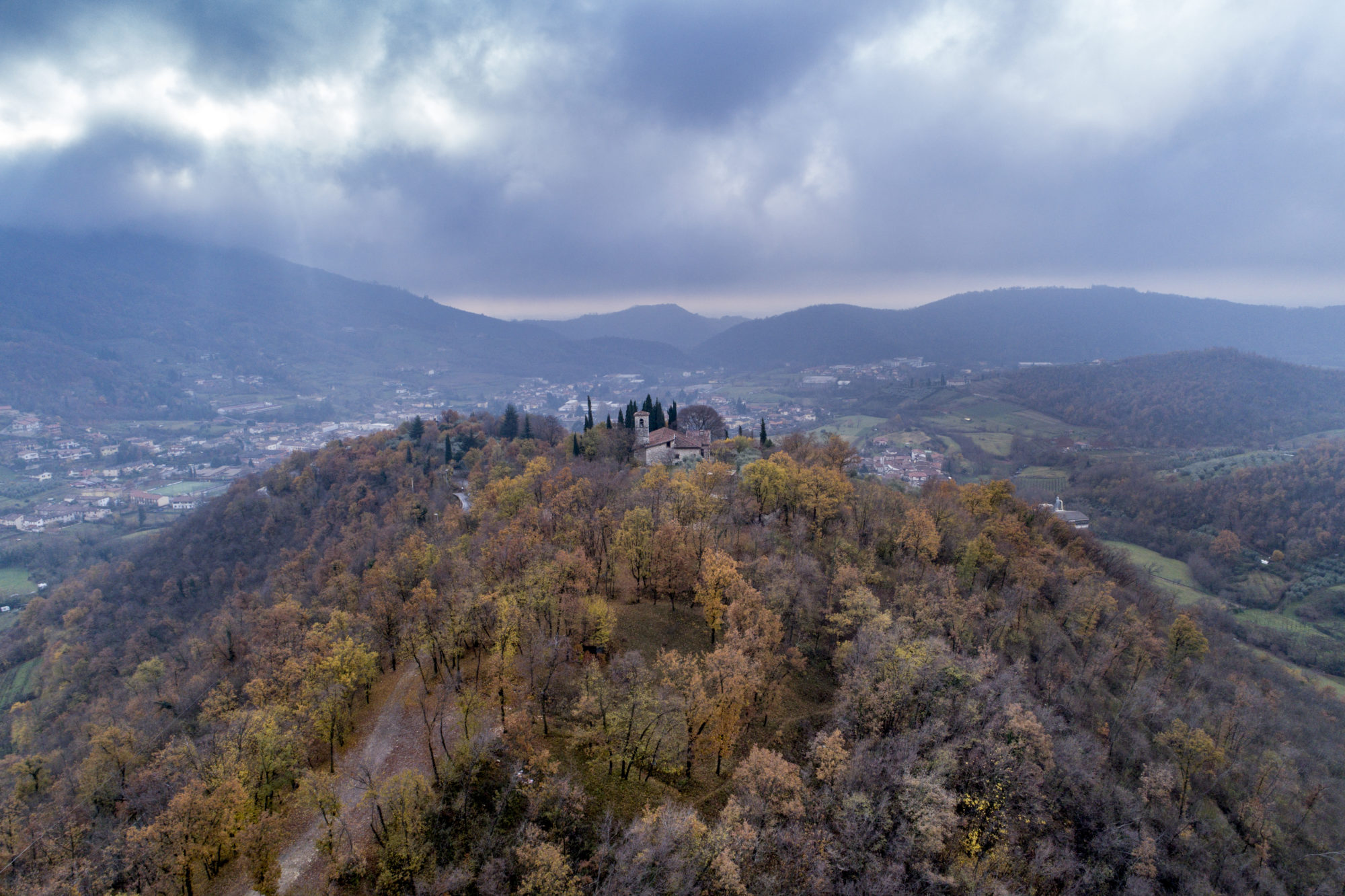 Foto di Una chiesetta sulla cima di una collina sotto un cielo nuvoloso in Franciacorta